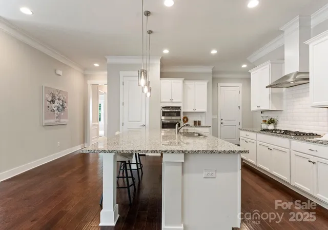 a large kitchen with stainless steel appliances granite countertop a stove a sink and a refrigerator