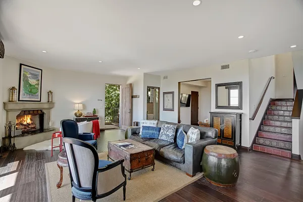 a living room with furniture fireplace and wooden floor
