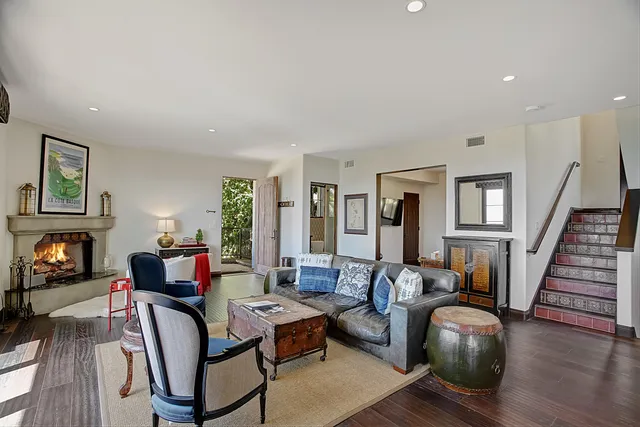 a living room with furniture fireplace and wooden floor