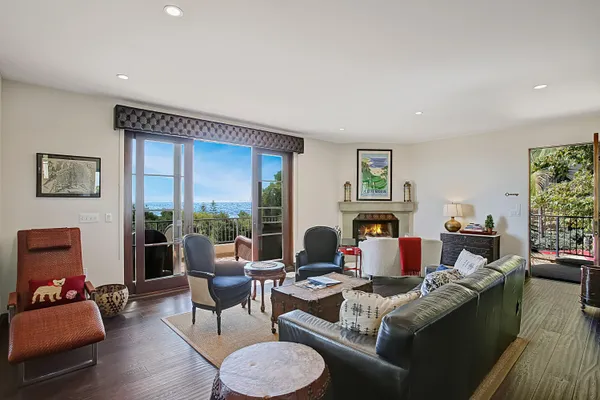 a living room with fireplace furniture and a large window
