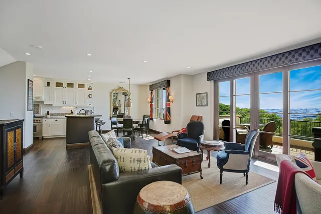 a living room with furniture a large window and wooden floor