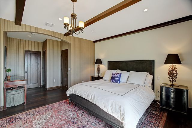 a bedroom with a bed and a lamp on dresser