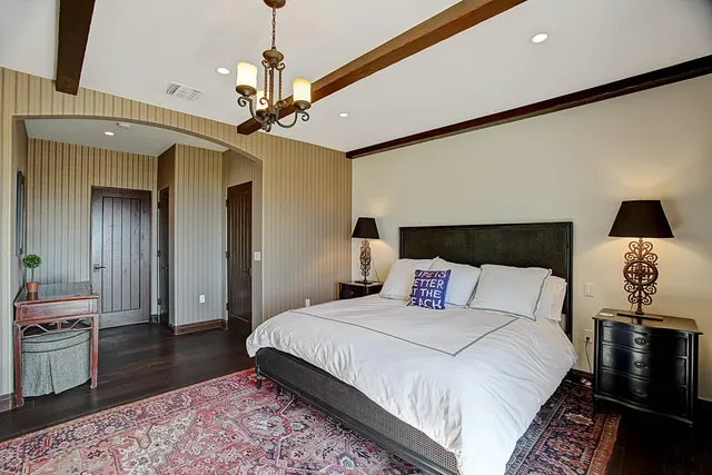 a bedroom with a bed and a lamp on dresser