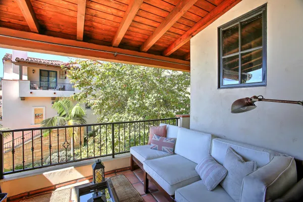 a balcony with furniture and next to a window