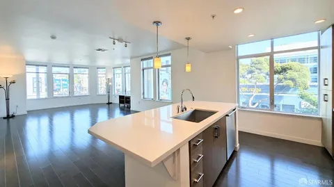 a kitchen with stainless steel appliances granite countertop a sink a stove and a wooden floor