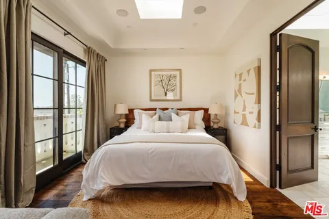 a bedroom with a bed and a large window