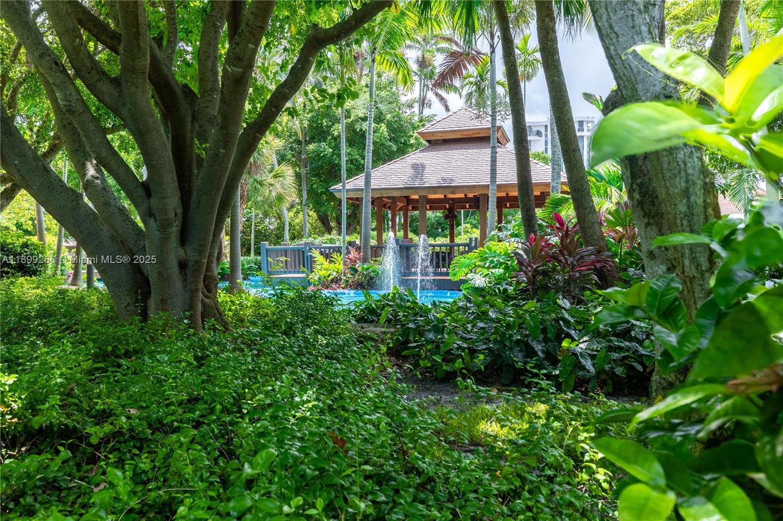 4000 Towerside Terrace, Unit 604 Miami, FL 33138 - Photo 38 of 79 a view of a garden with a table and chairs under an umbrella