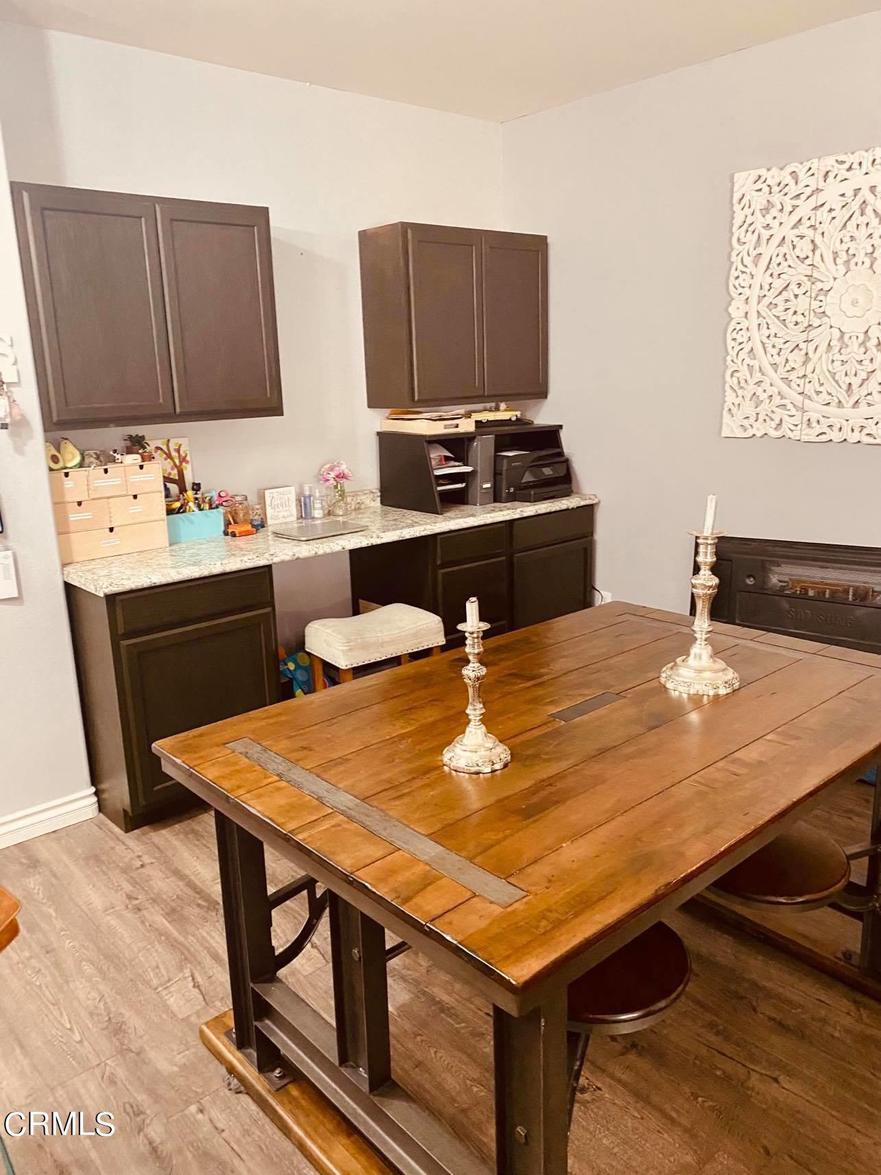 351 Riverpark Boulevard, Unit 202 Oxnard, CA 93036 - Photo 2 of 9 a room with stainless steel appliances kitchen island granite countertop a stove a sink and a microwave