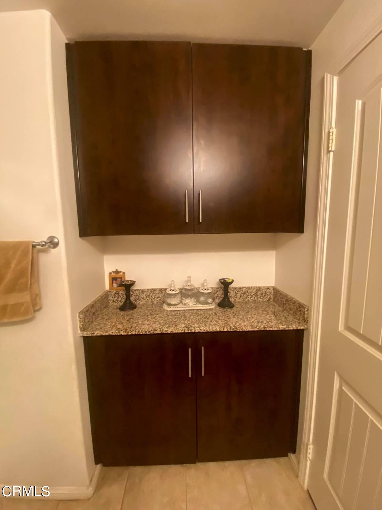 351 Riverpark Boulevard, Unit 202 Oxnard, CA 93036 - Photo 6 of 9 a bathroom with a granite countertop sink and a mirror