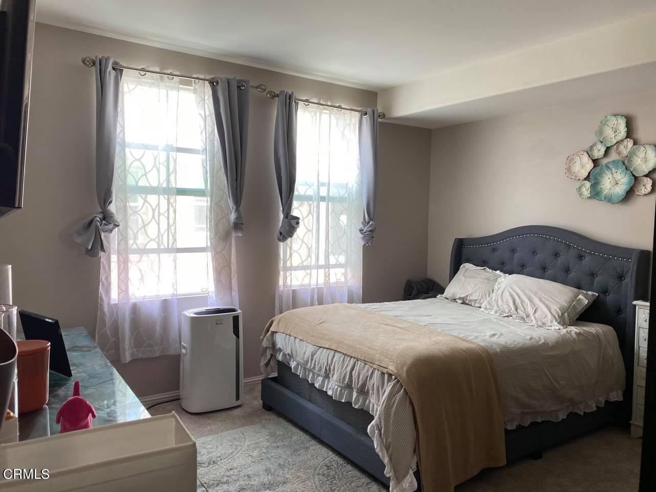 351 Riverpark Boulevard, Unit 202 Oxnard, CA 93036 - Photo 7 of 9 a bedroom with a bed and a window