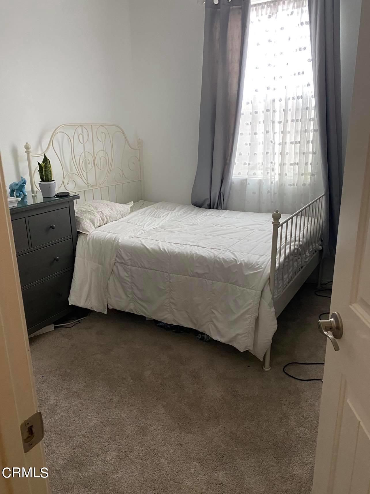 351 Riverpark Boulevard, Unit 202 Oxnard, CA 93036 - Photo 8 of 9 a bedroom with a bed and a window