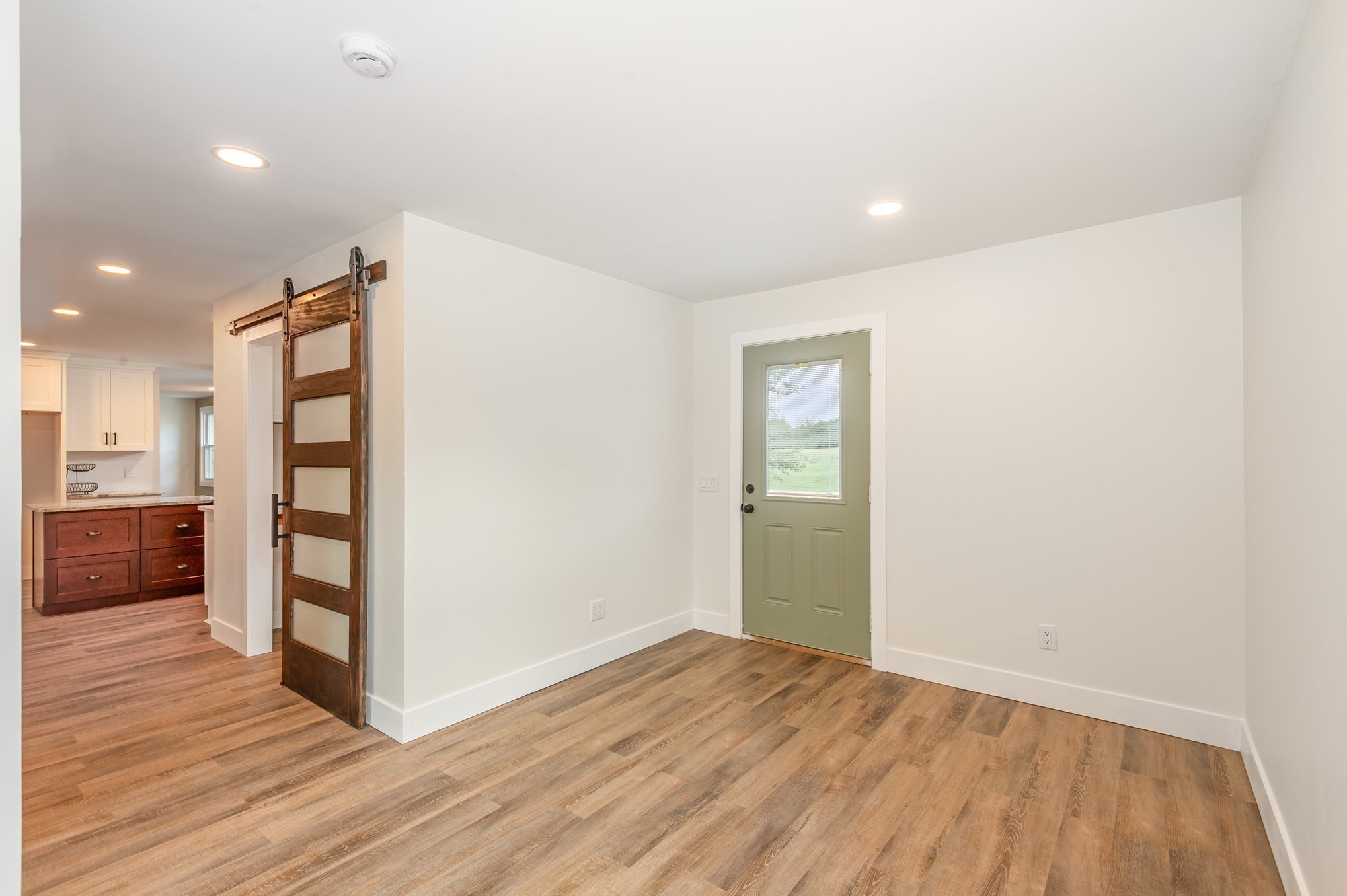 231 South Palmers Chapel Road White House, TN 37188 - Photo 14 of 40 a view of an empty room with wooden floor and a kitchen
