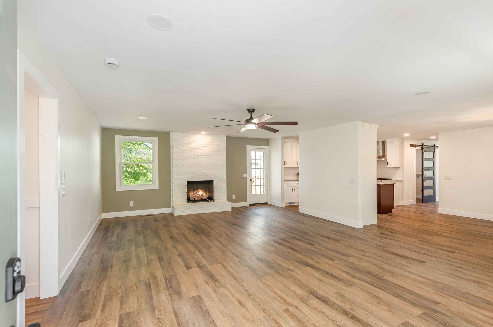 231 South Palmers Chapel Road White House, TN 37188 - Photo 6 of 40 an empty room with wooden floor fireplace and windows