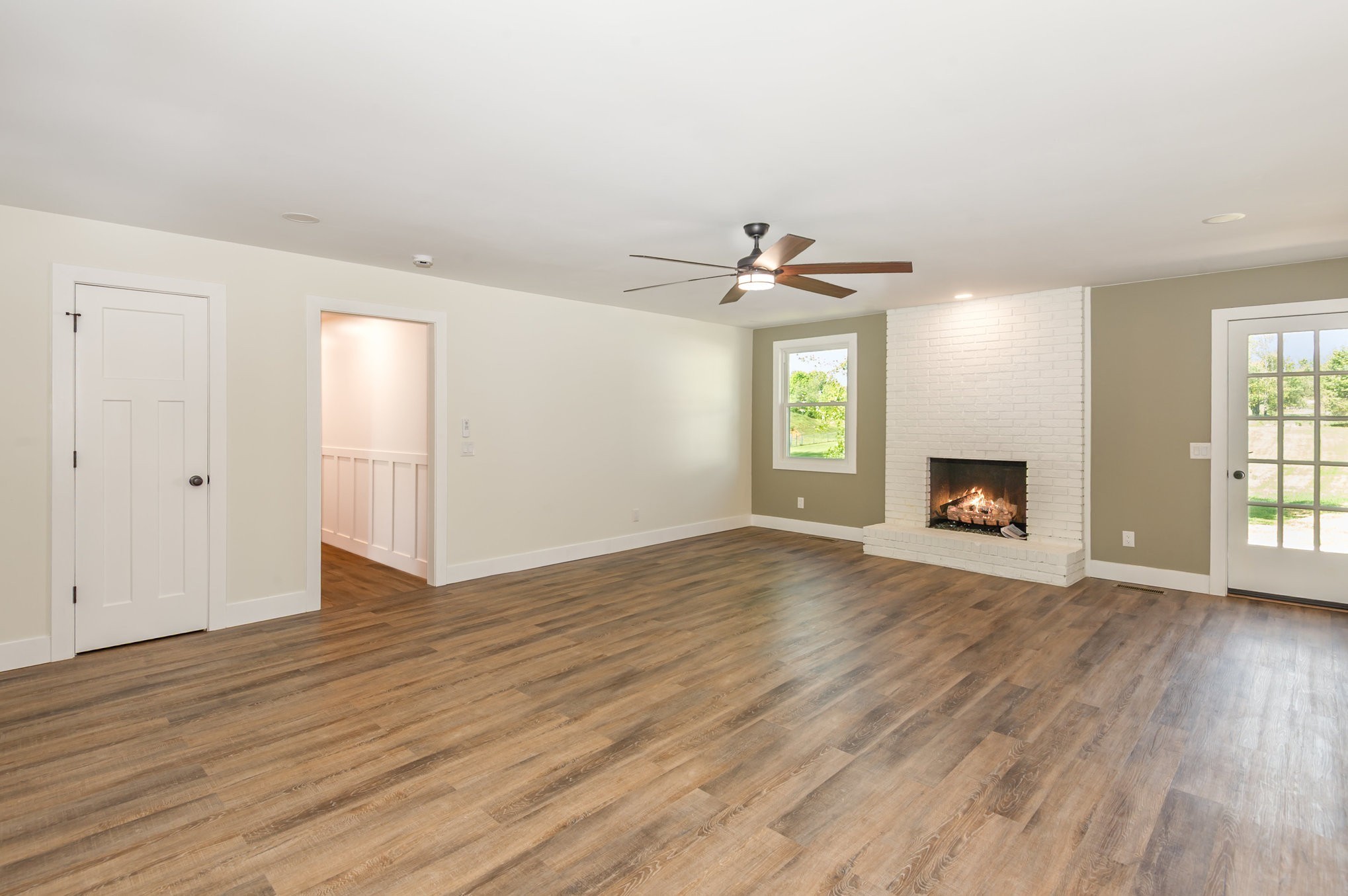 231 South Palmers Chapel Road White House, TN 37188 - Photo 7 of 40 an empty room with wooden floor fireplace and windows