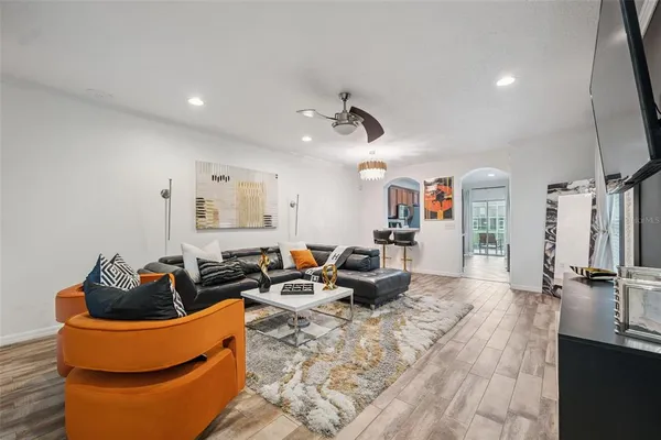 a living room with furniture a flat screen tv and a sink