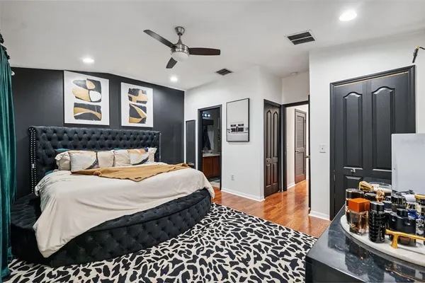 a bedroom with a bed and wooden floor