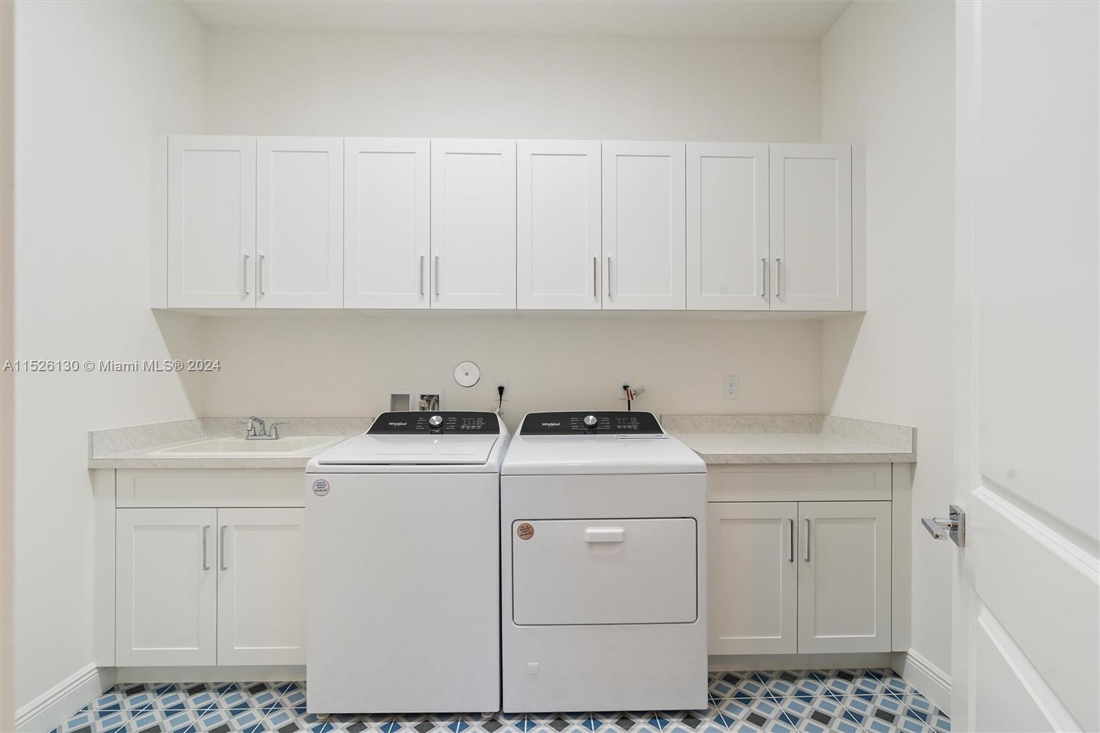 9345 Crestview Circle Palm Beach Gardens, FL 33412 - Photo 17 of 28 a view of cabinets with washer and dryer