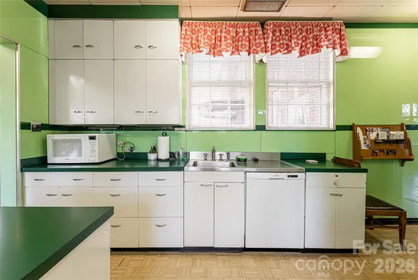 a kitchen with granite countertop white cabinets and white appliances