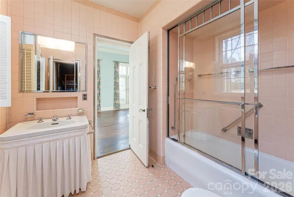 a bathroom with a double vanity sink a mirror and a shower