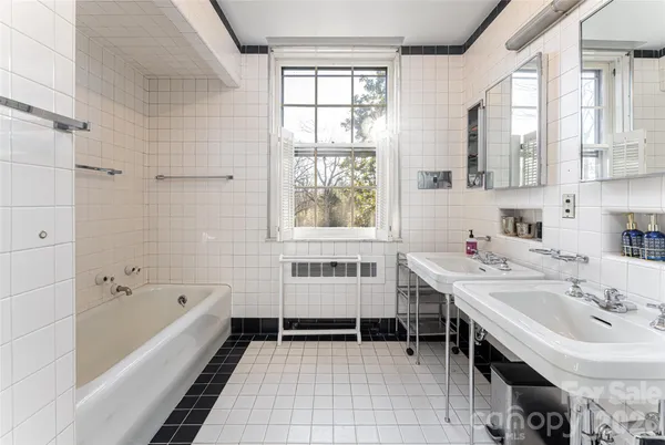 a bathroom with a tub sink and mirror