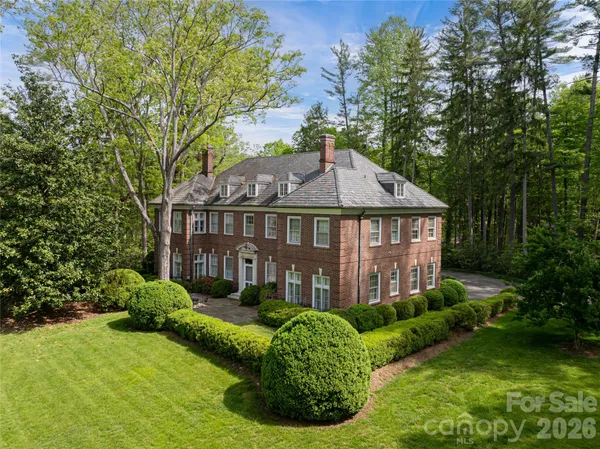 a aerial view of a house next to a big yard and large trees