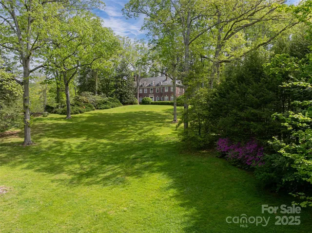 a yard with lots of green space and trees