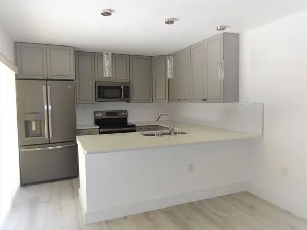a kitchen with a refrigerator a stove top oven a sink and dishwasher