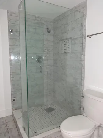 a white toilet next to a bathroom