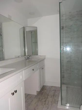 a bathroom with a double vanity sink and a mirror
