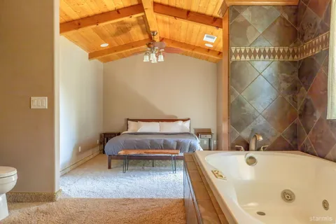 a bathroom with a tub a toilet and a shower