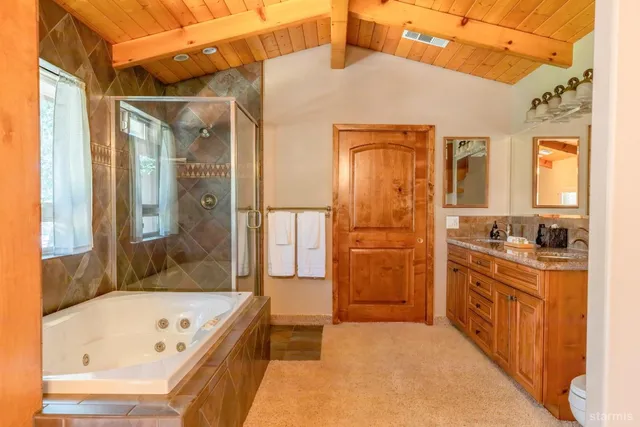 a bathroom with a tub a sink and a large mirror