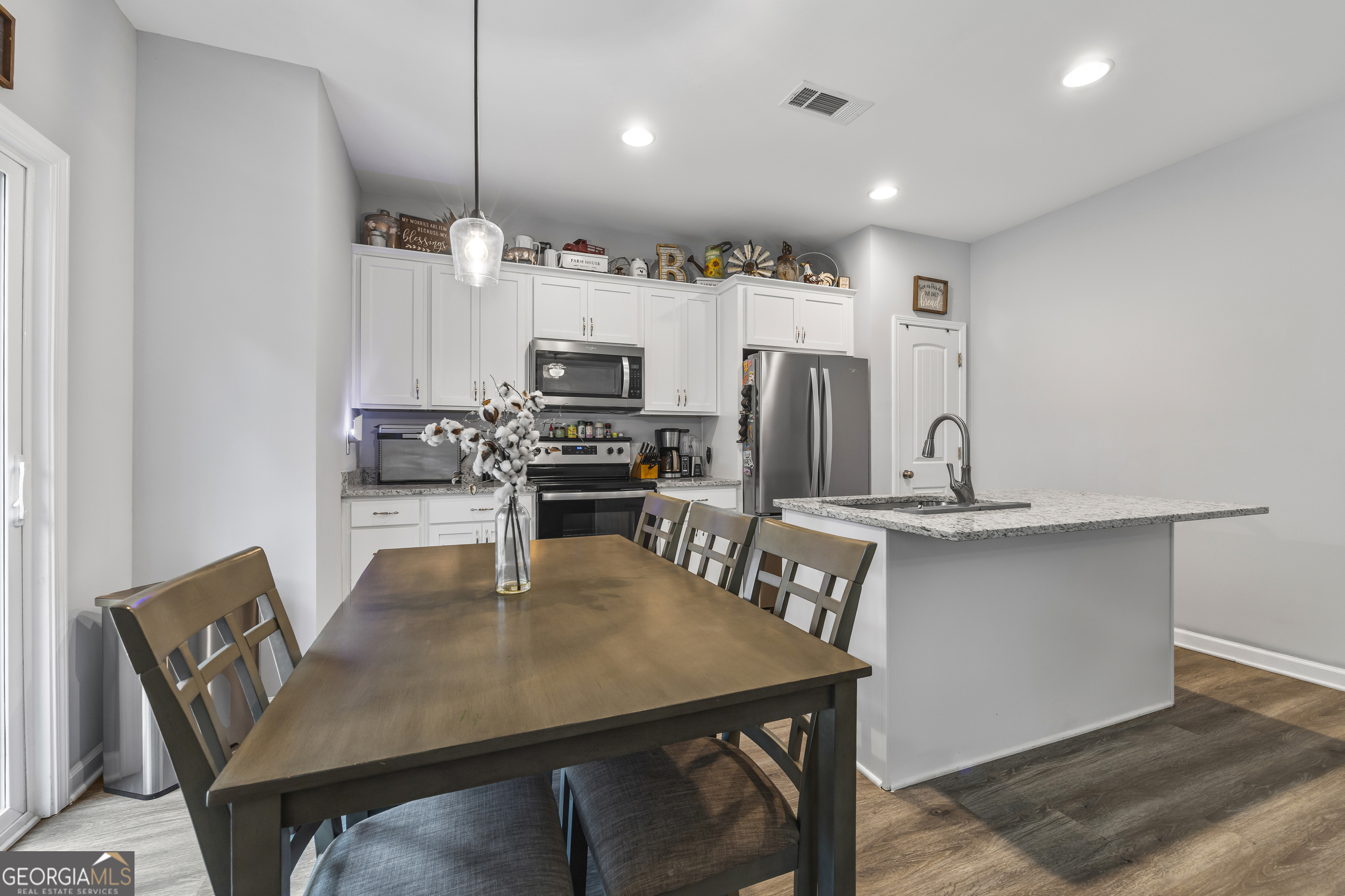 1350 Noah Crow Road Royston, GA 30662 - Photo 21 of 48 a kitchen with stainless steel appliances a white table chairs and a refrigerator