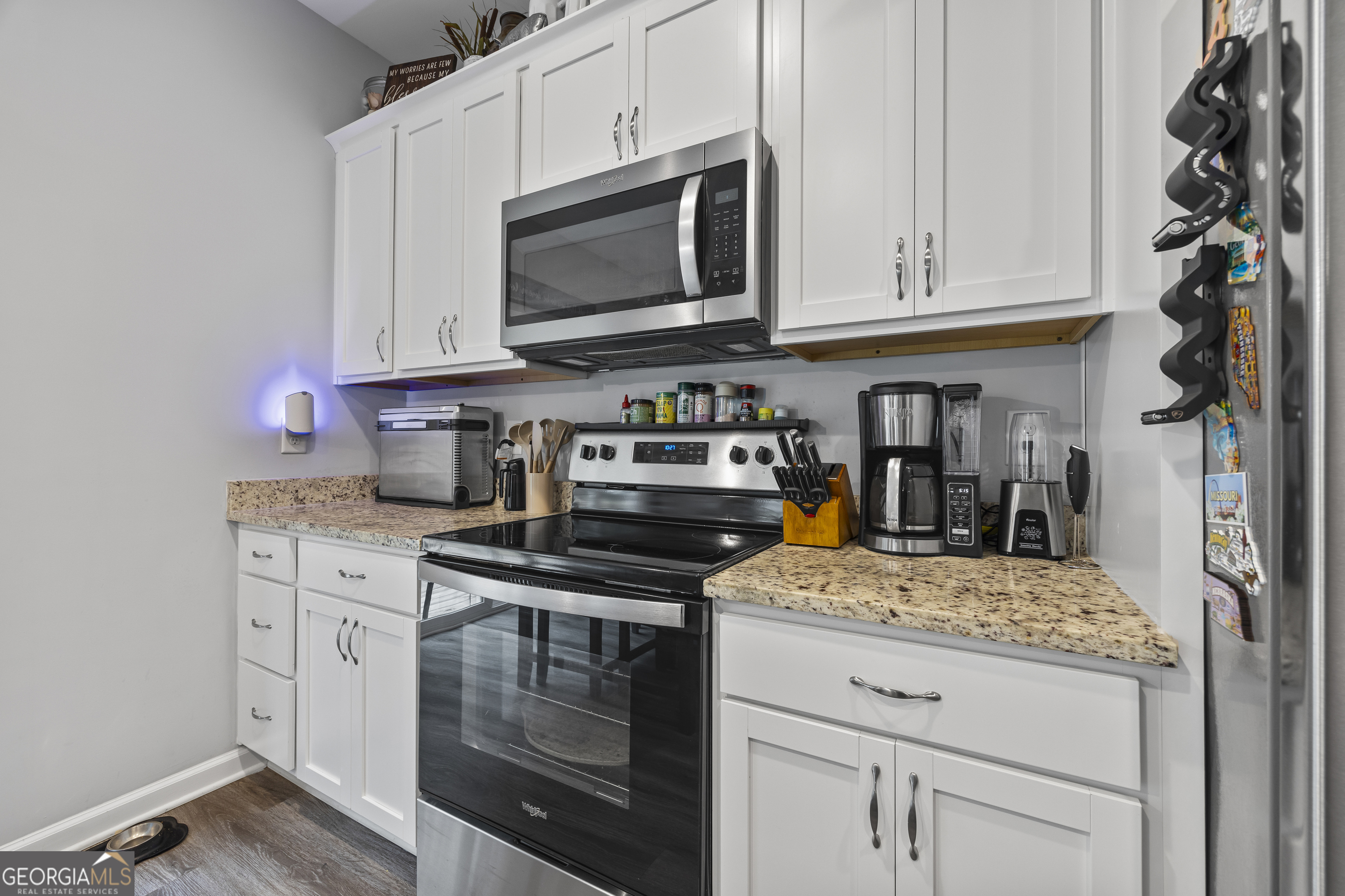 1350 Noah Crow Road Royston, GA 30662 - Photo 23 of 48 a kitchen with granite countertop white cabinets stainless steel appliances and a counter space