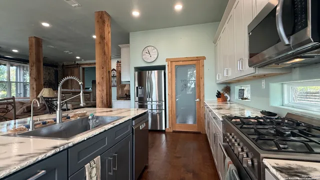 a kitchen with stainless steel appliances granite countertop a sink stove and refrigerator