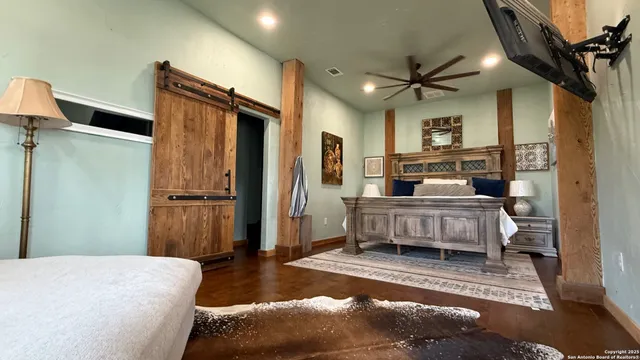 a bedroom with a bed next to a window and a chandelier