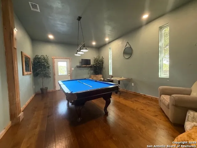 a room with pool table and windows