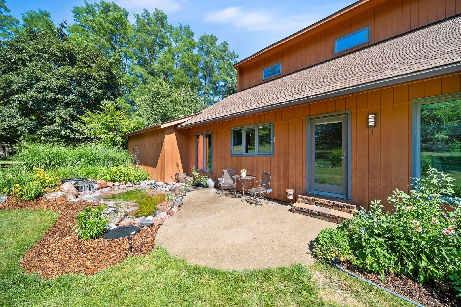 a view of a house with backyard and sitting area