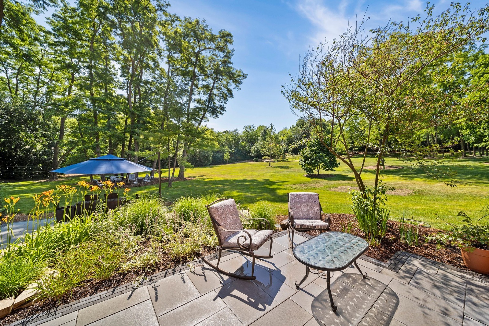 37W271 Weld Road Elgin, IL 60124 - Photo 4 of 24 a view of a table and chairs under an umbrella with large trees