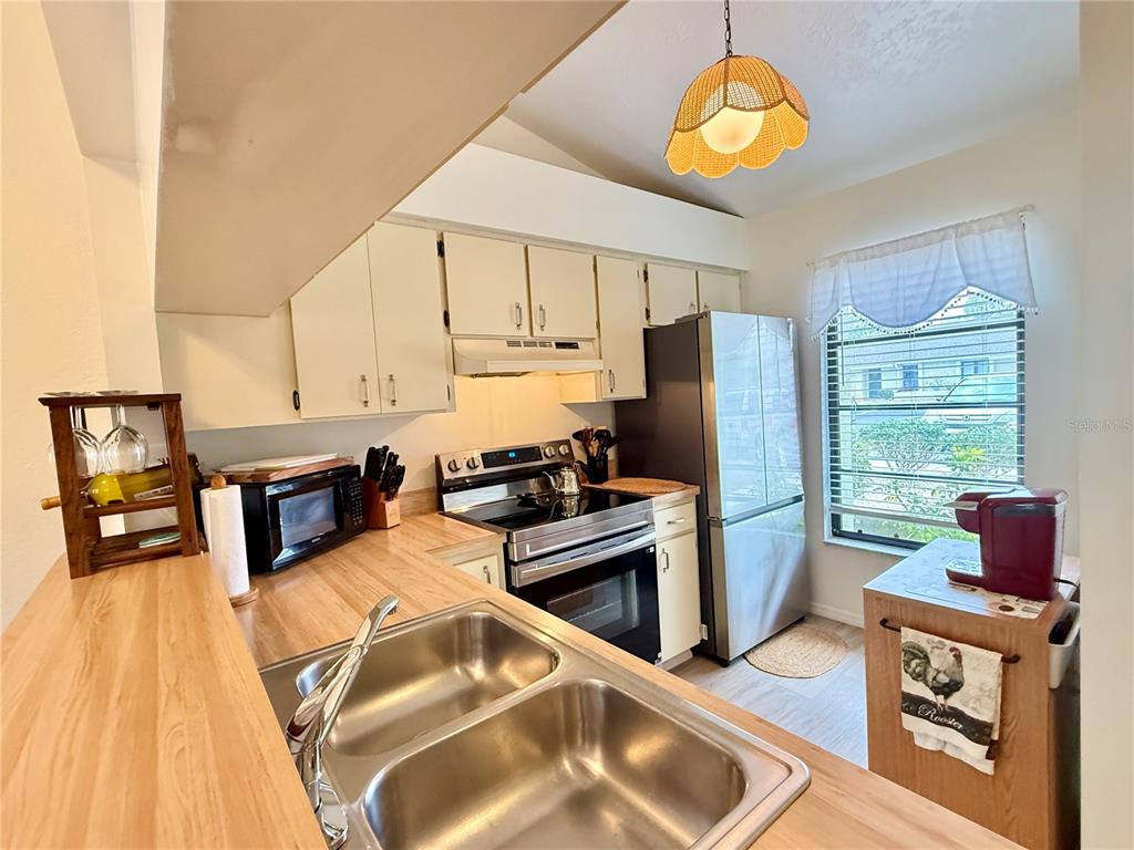 26267 Northern Cross Road, Unit 1A Punta Gorda, FL 33983 - Photo 11 of 34 a kitchen with stainless steel appliances granite countertop a stove refrigerator and a stove