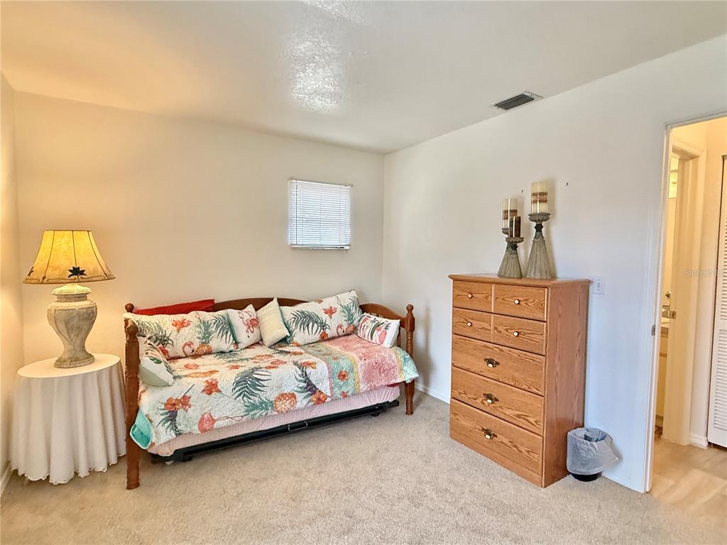 26267 Northern Cross Road, Unit 1A Punta Gorda, FL 33983 - Photo 21 of 34 a bedroom with a bed and a dresser
