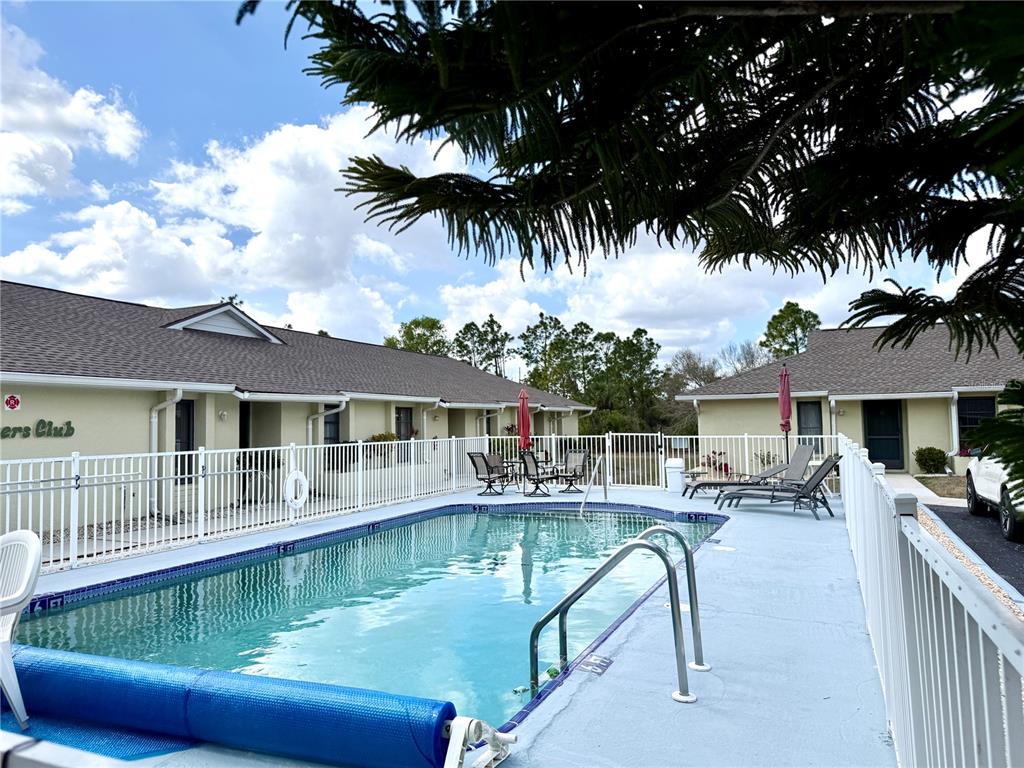 26267 Northern Cross Road, Unit 1A Punta Gorda, FL 33983 - Photo 27 of 34 a swimming pool view with a seating space and a garden