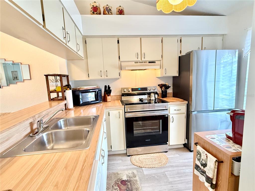 26267 Northern Cross Road, Unit 1A Punta Gorda, FL 33983 - Photo 9 of 34 a kitchen with a stove a sink and a refrigerator