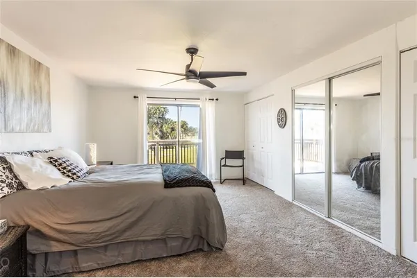 a spacious bedroom with a bed and glass walk in closet
