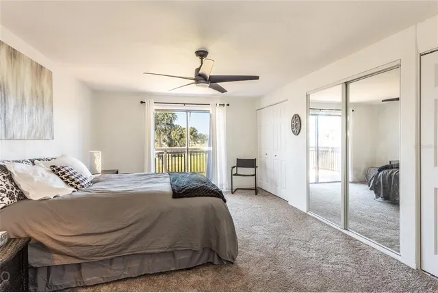 a spacious bedroom with a bed and glass walk in closet