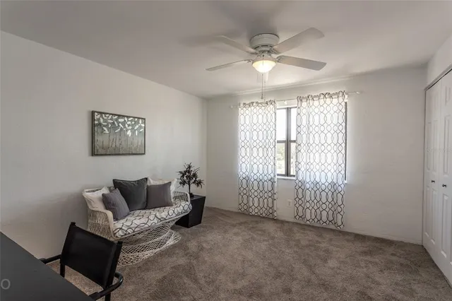 a living room with furniture and a ceiling fan
