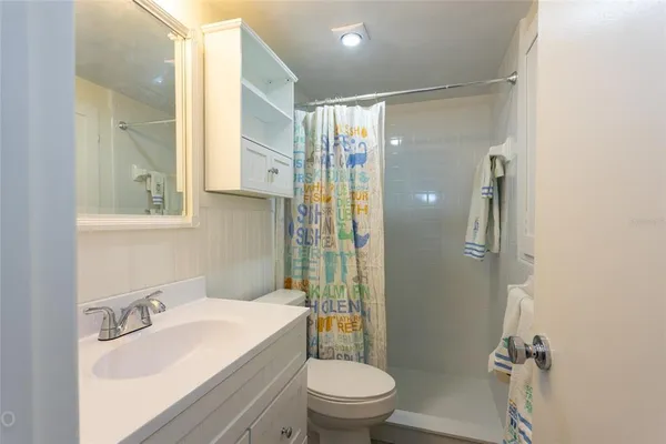 a bathroom with a sink toilet vanity and shower