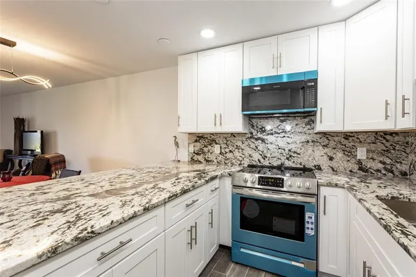 a kitchen with stainless steel appliances granite countertop a sink stove and microwave