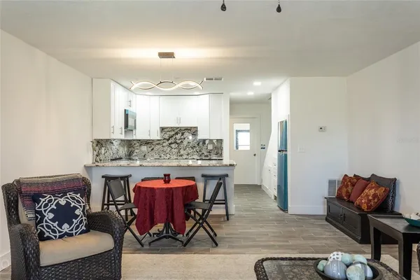 a kitchen with stainless steel appliances granite countertop a kitchen island a table and chairs in it