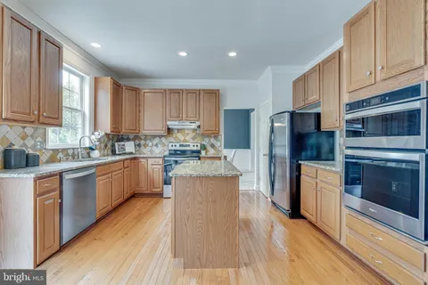 a kitchen with stainless steel appliances granite countertop sink stove top oven and cabinets