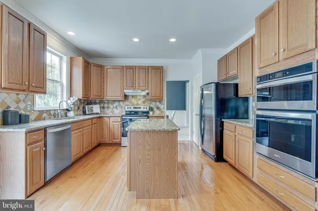 a kitchen with stainless steel appliances granite countertop sink stove top oven and cabinets